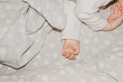 Low section of baby boy sleeping on bed at home