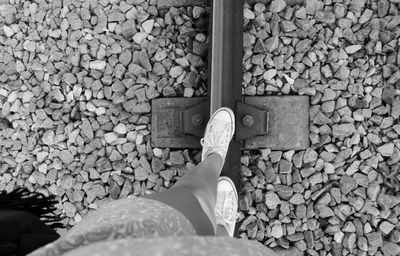 Low section of woman walking on railroad track