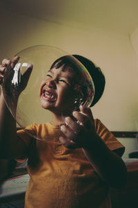 Midsection of boy blowing bubbles