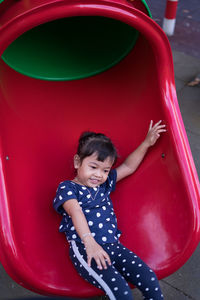 High angle view of happy girl sliding in playground