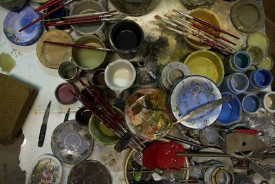 High angle view of paintbrushes and cans on table