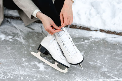 Pictured are hands tying ice skates. a young woman came to skate on an ice rink. winter fun