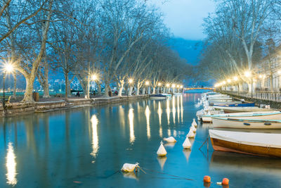 Boats moored in lake at dusk