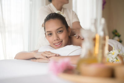 Portrait of young woman being massaged on table in spa