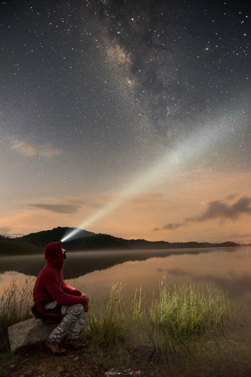 MAN SITTING ON GRASS AT NIGHT