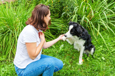 Young woman with dog on grassy field