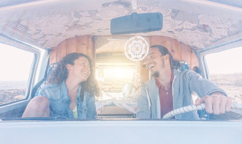 Happy couple sitting at car