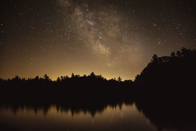Scenic view of silhouette trees against sky at night