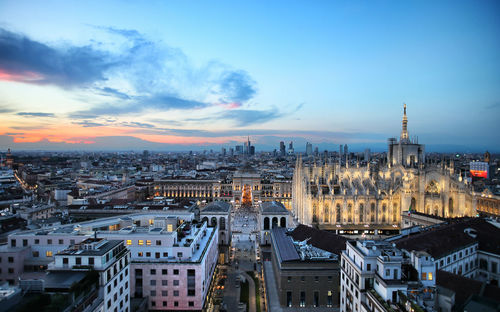 High angle view of illuminated city against sky during sunset