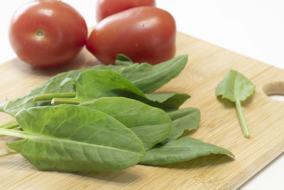 Close-up of fruits and leaves on cutting board