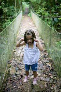 Full length of girl standing on footbridge