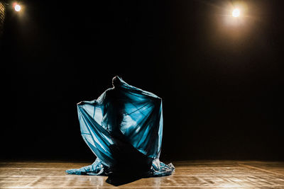 Close-up of illuminated lighting equipment on table against black background