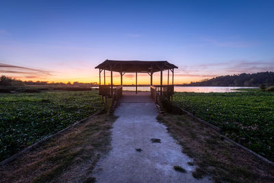 Lifeguard hut on land against sky during sunset