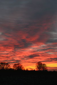 Scenic view of dramatic sky over silhouette landscape