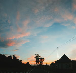 Low angle view of silhouette trees against dramatic sky