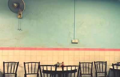 Chairs and tables against wall