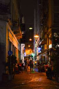 People in illuminated city at night