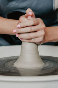 Midsection of woman at pottery workshop