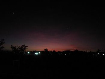 Low angle view of silhouette trees against sky at night