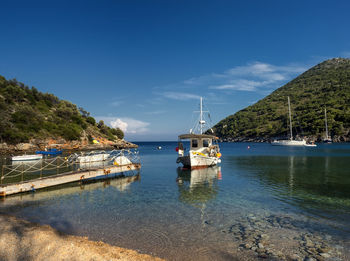 Sailboats moored on sea against sky