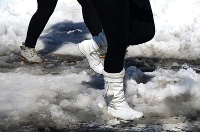 Low section of person standing in water