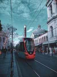 Cars on street in city against sky