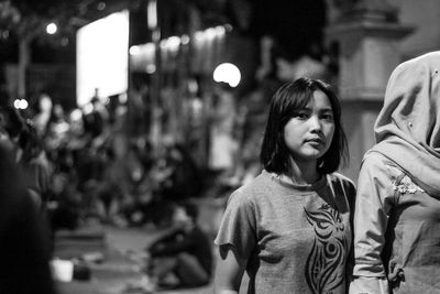 Portrait of friends standing on street in city