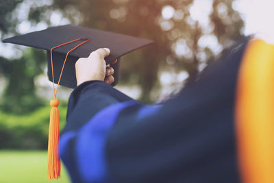 Close-up of person holding mortarboard