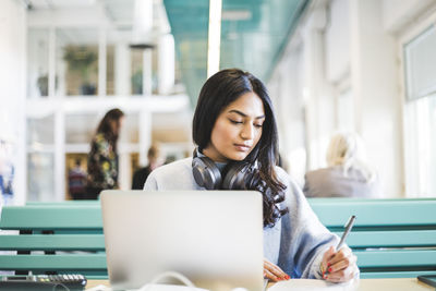 Young female student studying at cafeteria in university