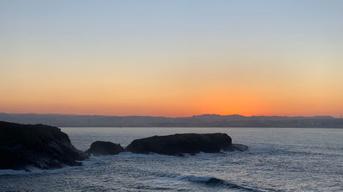 Scenic view of sea against clear sky during sunset