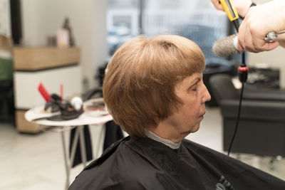An elderly woman in a beauty salon does her hair