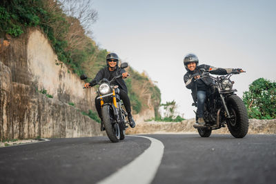 Man riding motor scooter on road