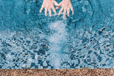 Cropped hands of person in swimming pool
