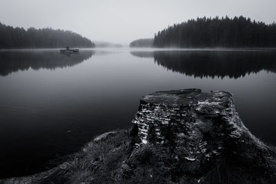 Scenic view of lake in forest against sky