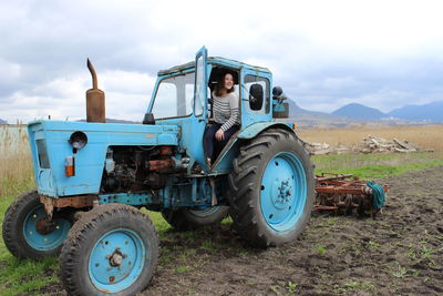 The girl on the tractor in the field. plow the tractor land in the fall. agricultural work. 