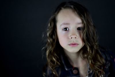 Portrait of girl against black background