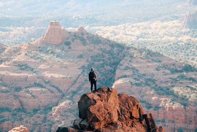 Rear view of man standing on rock formation