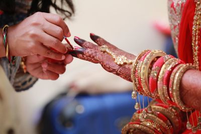 Cropped hands applying nail polish for bride