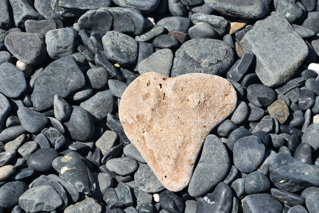 rock, heart shape, love, positive emotion, stone, soil, emotion, no people, high angle view, day, full frame, pebble, large group of objects, textured, backgrounds, nature, shape, directly above, abundance, outdoors, close-up, gravel, heart, cobblestone, gray, pattern, still life