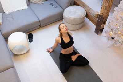 High angle view of woman meditating at home