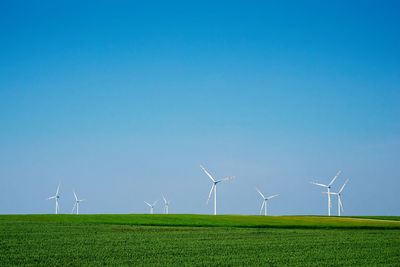 Windmill turbines in green field, wind energy concept