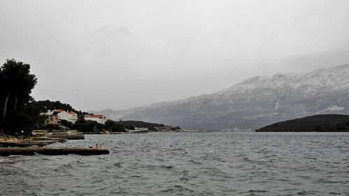 Scenic view of sea and mountains against sky