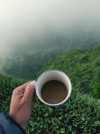 Midsection of person holding tea cup