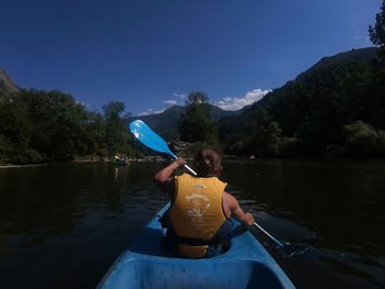 Man holding boat in lake against sky