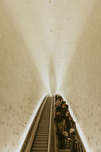 Low angle view of people standing on escalator