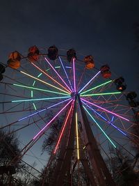 Low angle view of illuminated ferris wheel against sky at night