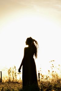 Silhouette woman standing on field against clear sky