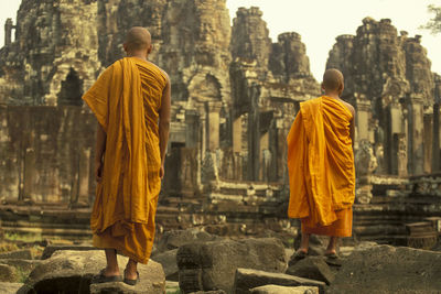 Rear view of men outside temple against building