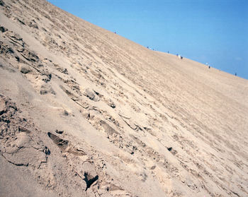 Scenic view of sand dunes against clear blue sky