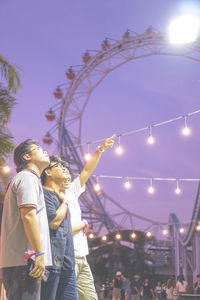 Rear view of couple standing at illuminated night